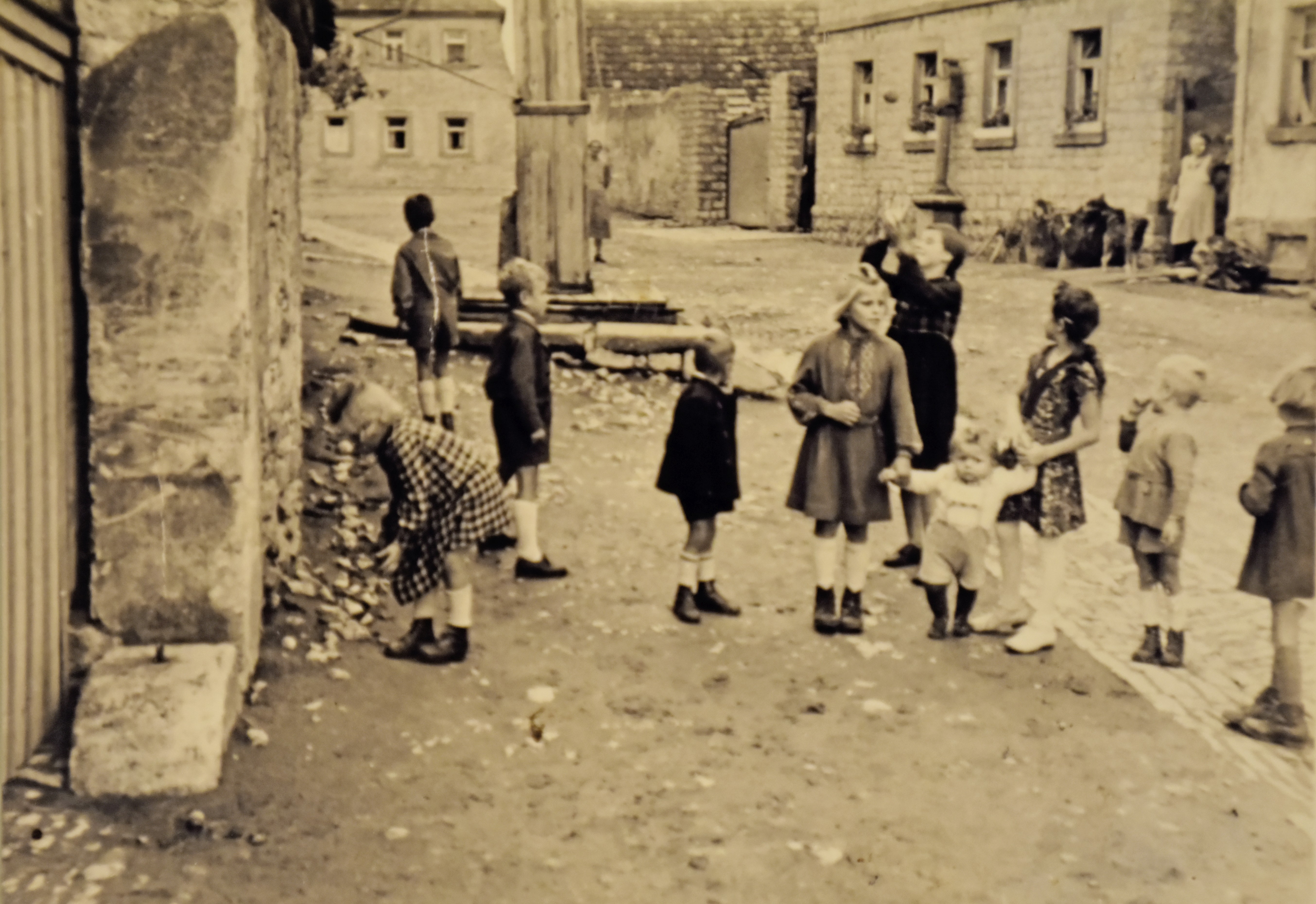 Kinder spielen am Dorfbrunnen (Anfang 20. Jahrhundert)